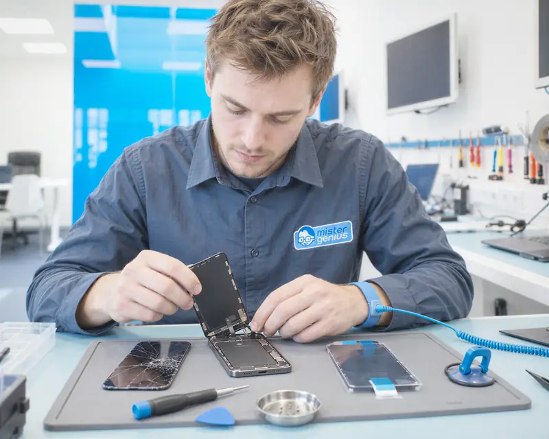Technicien Mister Genius remplaçant l'écran d'un smartphone à l'atelier