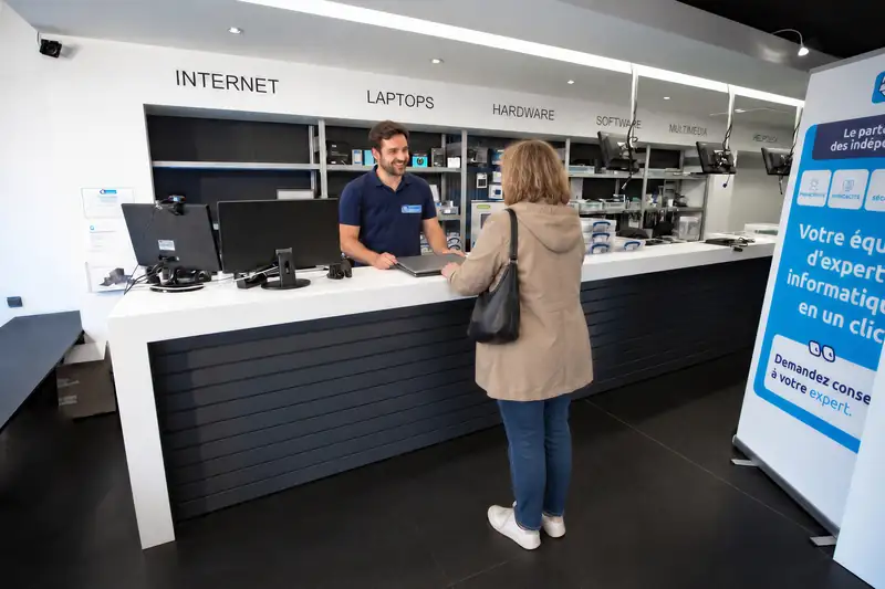 Mister Genius technician welcoming customer at Jette counter