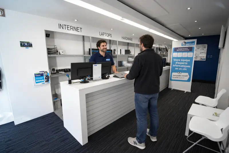 Mister Genius technician welcoming customer at Uccle counter