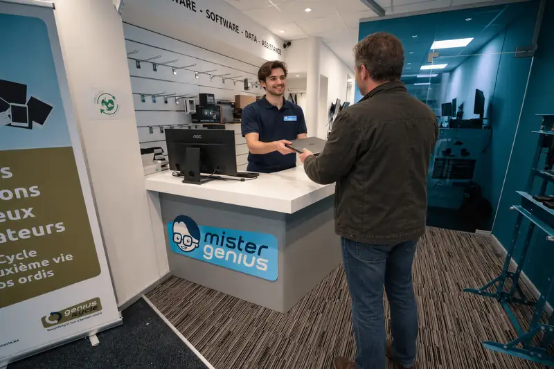 Mister Genius technician receiving laptop at Wavre counter