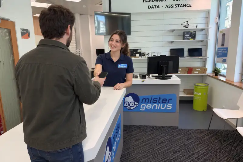 Mister Genius technician and customer with smartphone at Woluwe-Saint-Lambert counter